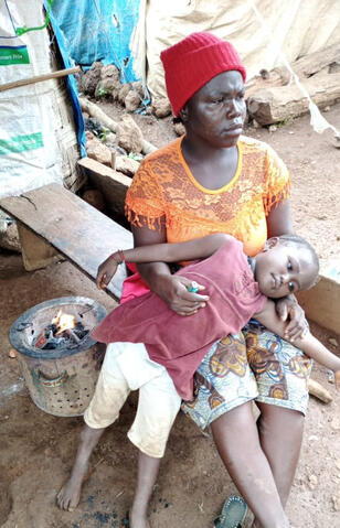 A woman and child stare out on the village waiting for news